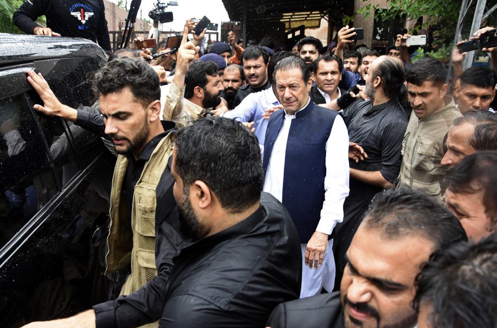 Former Pakistani Prime Minister Imran Khan, center, leaves an anti-terrorism court in Islamabad, Pakistan, Thursday, Aug. 25, 2022. The court on Thursday extended former premier Imran Khan’s protection from arrest through the end of the month, officials said, after police filed terrorism charges against the country’s popular opposition leader. (AP Photo/W.K. Yousafzai)