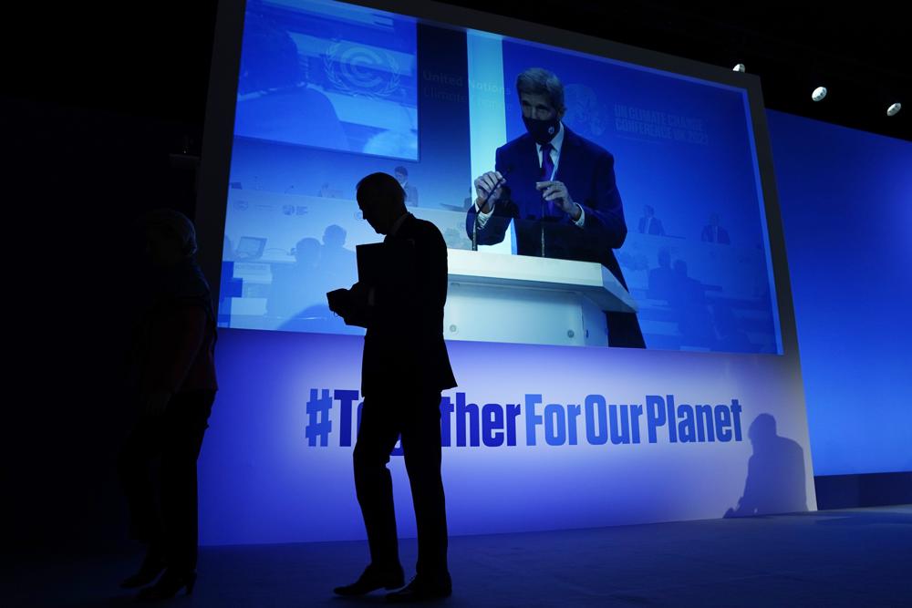 FILE – President Joe Biden walks off after speaking during an event about the “Global Methane Pledge” at the COP26 U.N. Climate Summit, Nov. 2, 2021, in Glasgow, Scotland, as John Kerry, United States Special Presidential Envoy for Climate takes the podium, shown on the screen. The U.S. has renewed legitimacy on global climate issues and will be able to inspire other nations in their own emissions-reducing efforts, experts said, after the Democrats pushed their big economic bill through the Senate on Sunday, Aug. 7. (AP Photo/Evan Vucci, File)
