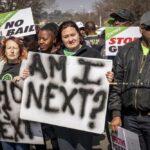 Women protest outside the Krugersdorp, South Africa, Magistrates Court Monday, Aug. 1, 2022. More than 80 men suspected of the gang rapes of eight women and armed robbery of a video production crew in the ming town, west of Johannesburg appeared in court on Monday. (AP Photo/Shiraaz Mohamed)