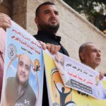 People hold pictures of Mohammad El Halabi, during a solidarity gathering following an Israeli court decision to sentence him for 12 years, outside the office of the International Committee of the Red Cross in Gaza City August 30, 2022. REUTERS/Mohammed Salem