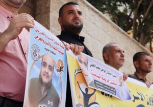 People hold pictures of Mohammad El Halabi, during a solidarity gathering following an Israeli court decision to sentence him for 12 years, outside the office of the International Committee of the Red Cross in Gaza City August 30, 2022. REUTERS/Mohammed Salem