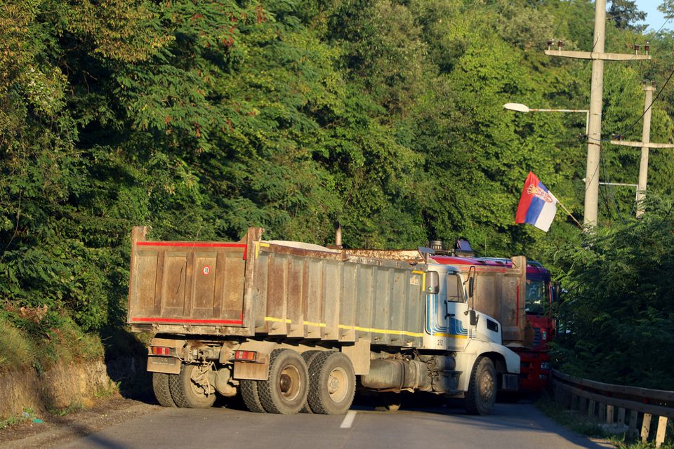 A Serbian flag is seen as trucks block a road in Zupce, Kosovo August 1, 2022. REUTERS/Fatos Bytyci/File Photo