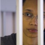 FILE – US Basketball player Brittney Griner looks through bars as she listens to the verdict standing in a cage in a courtroom in Khimki, outside Moscow, Russia, Thursday, Aug. 4, 2022. Lawyers for American basketball star Brittney Griner on Monday, Aug. 15, 2022 filed an appeal of her nine-year Russian prison sentence for drugs possession. Griner, a center for the Phoenix Mercury and a two-time Olympic gold medalist, was convicted on Aug. 4. She was arrested in February at Moscow’s Sheremetyevo Airport after vape canisters containing cannabis oil were found in her luggage. (Evgenia Novozhenina/Pool Photo via AP, File)