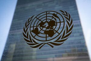 FILE – The symbol of the United Nations is displayed outside the Secretariat Building during an emergency meeting of the UN General Assembly, Monday, Feb. 28, 2022, at the United Nations Headquarters, in New York. As 191 countries approach the end to a four-week conference to review the landmark U.N. treaty aimed at curbing the spread of nuclear weapons, Russia’s invasion of Ukraine and takeover of Europe’s largest nuclear power plant and rivalries between the West and China were posing key obstacles to agreement on a final document. (AP Photo/John Minchillo, File)