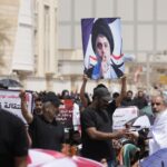 Supporters of Shiite cleric Muqtada al-Sadr with his poster gather during an open-air Friday prayers near the parliament building in Baghdad, Iraq, Friday, Aug. 26, 2022. Al-Sadr’s supporters continue their sit-in outside the parliament to demand early elections. (AP Photo/Hadi Mizban)