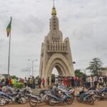 FILE – People gather at Place de l’Independence in Mali’s capital Bamako, Aug. 19, 2020. Bamako, Mali’s bustling riverside capital of more than 2.5 million people is on heightened alert as jihadi attacks have moved perilously close to the city. At least 15 extremist attacks hit Mali in June and July, the most daring when jihadi fighters attacked Kati, the country’s largest military base, just 9 miles outside the capital. (AP Photo/Arouna Sissoko, File)