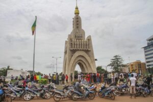 FILE – People gather at Place de l’Independence in Mali’s capital Bamako, Aug. 19, 2020. Bamako, Mali’s bustling riverside capital of more than 2.5 million people is on heightened alert as jihadi attacks have moved perilously close to the city. At least 15 extremist attacks hit Mali in June and July, the most daring when jihadi fighters attacked Kati, the country’s largest military base, just 9 miles outside the capital. (AP Photo/Arouna Sissoko, File)