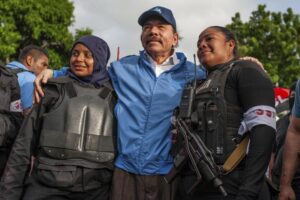 FILE – Nicaraguan police have their picture taken with President Daniel Ortega, in Masaya, Nicaragua, Friday, July 13, 2018. Ortega’s government has closed seven radio stations owned by the Roman Catholic church on the first week of August 2022, as well as two other outlets serving the largely rural northern area with a history of opposition to his Sandinista National Liberation Front party. (AP Photo/Cristobal Venegas File)