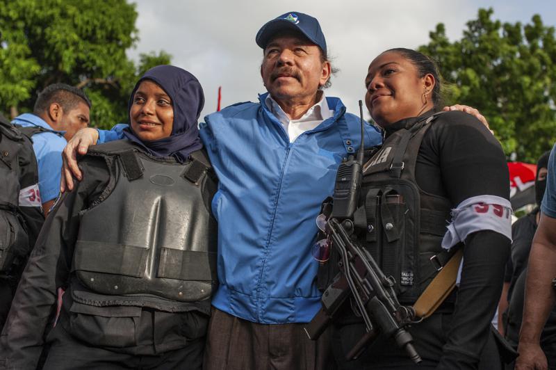 FILE – Nicaraguan police have their picture taken with President Daniel Ortega, in Masaya, Nicaragua, Friday, July 13, 2018. Ortega’s government has closed seven radio stations owned by the Roman Catholic church on the first week of August 2022, as well as two other outlets serving the largely rural northern area with a history of opposition to his Sandinista National Liberation Front party. (AP Photo/Cristobal Venegas File)