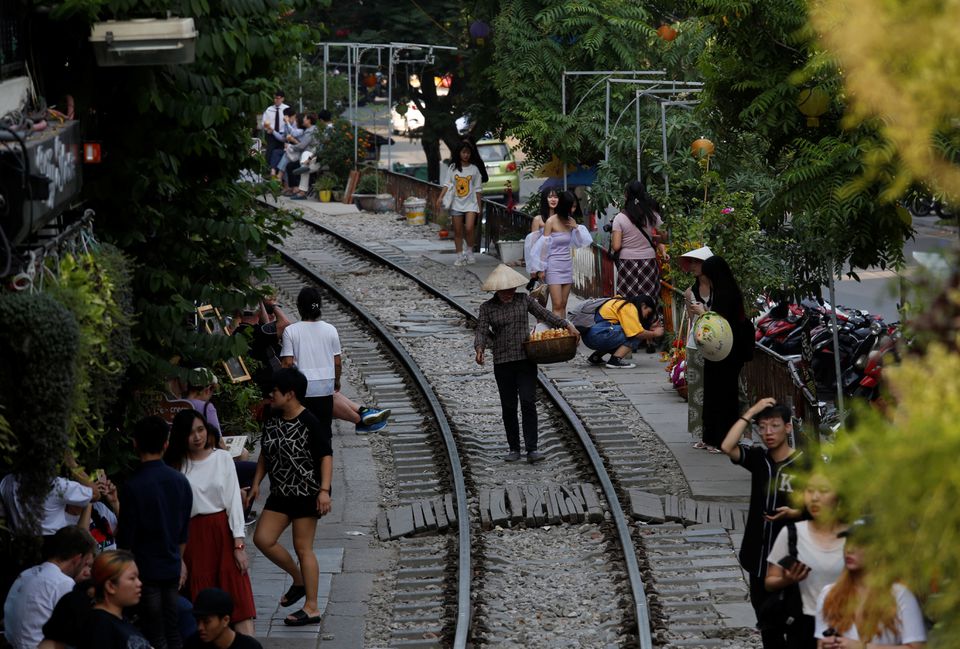A vendor walks on a railway track as tourists gather on either side, in the Old Quarter of Hanoi, Vietnam September 28, 2019. REUTERS/Kham