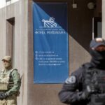 Russian law enforcement officers stand guard outside the office of Roizman Charity Fund, after its founder and politician Yevgeny Roizman was reportedly detained in Yekaterinburg, Russia August 24, 2022. REUTERS/Stringer