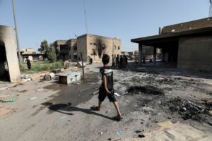 A boy walks near the office of Badr Organization, which was burned by supporters of Iraqi populist leader Moqtada al-Sadr, in Baghdad, Iraq August 30, 2022. REUTERS/Wissam Al-Okaili