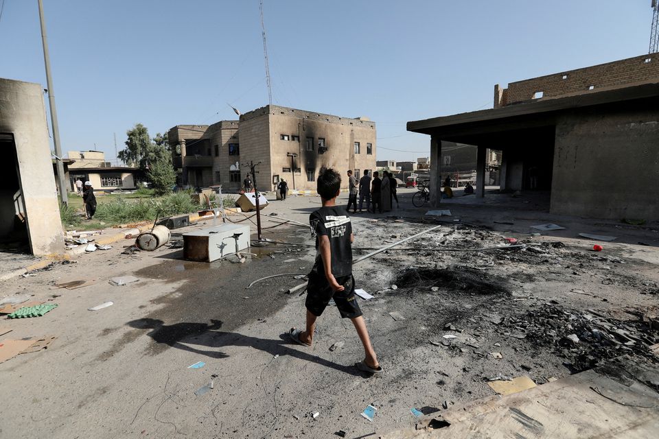 A boy walks near the office of Badr Organization, which was burned by supporters of Iraqi populist leader Moqtada al-Sadr, in Baghdad, Iraq August 30, 2022. REUTERS/Wissam Al-Okaili