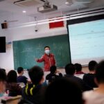 A teacher wearing a face mask teaches inside a classroom during a government-organised media tour at a high school as more students returned to campus following the coronavirus disease (COVID-19) outbreak, in Shanghai, China May 7, 2020. REUTERS/Aly Song