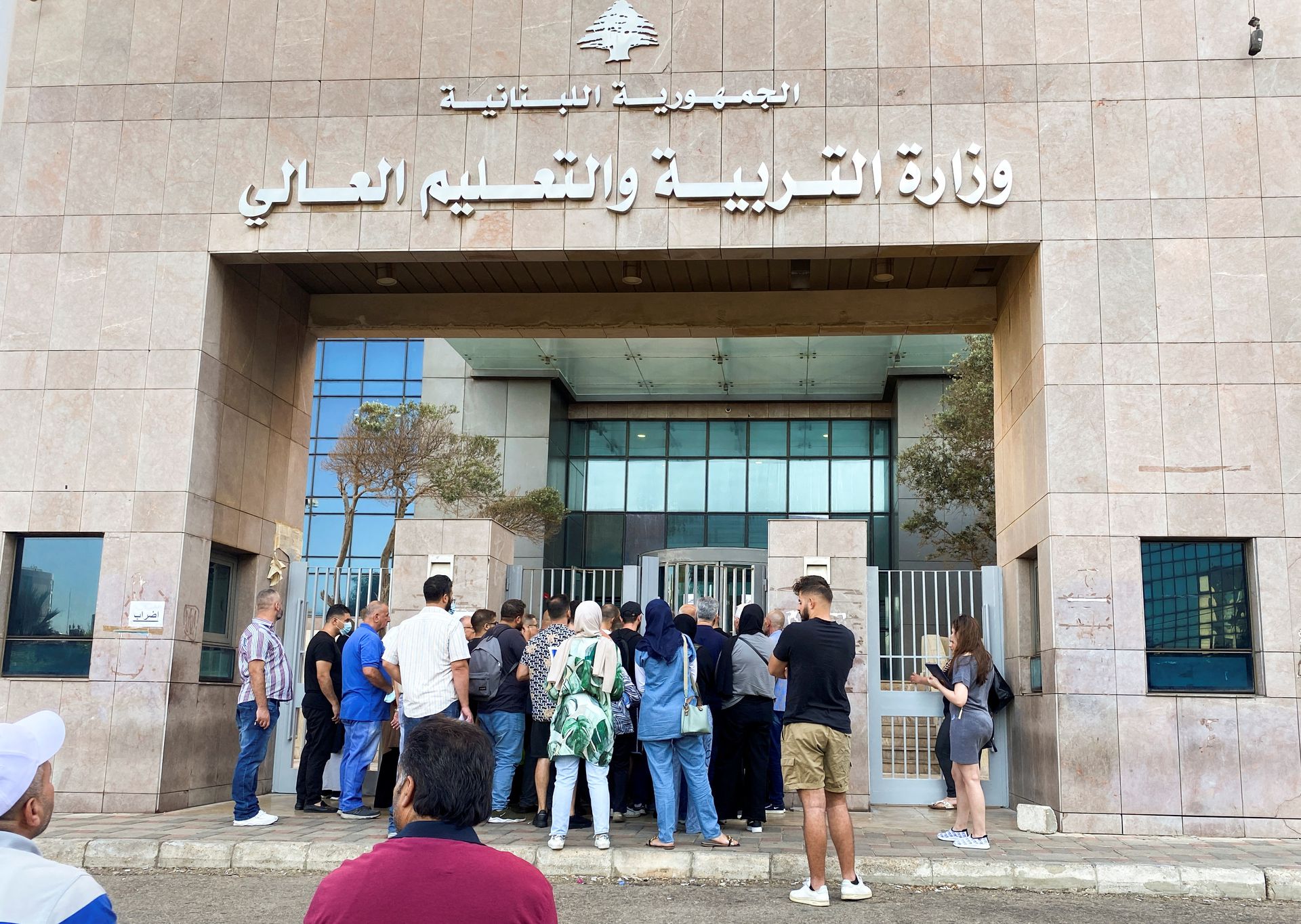 People gather at an entrance of the Ministry of Education and Higher Education during intermittent workers strike in Beirut, Lebanon August 17, 2022. REUTERS/Mohamed Azakir