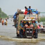 A family puts their belongings on a higher ground as they travel, following rains and floods during the monsoon season in Sohbatpur, Pakistan August 29, 2022. REUTERS/Amer Hussain