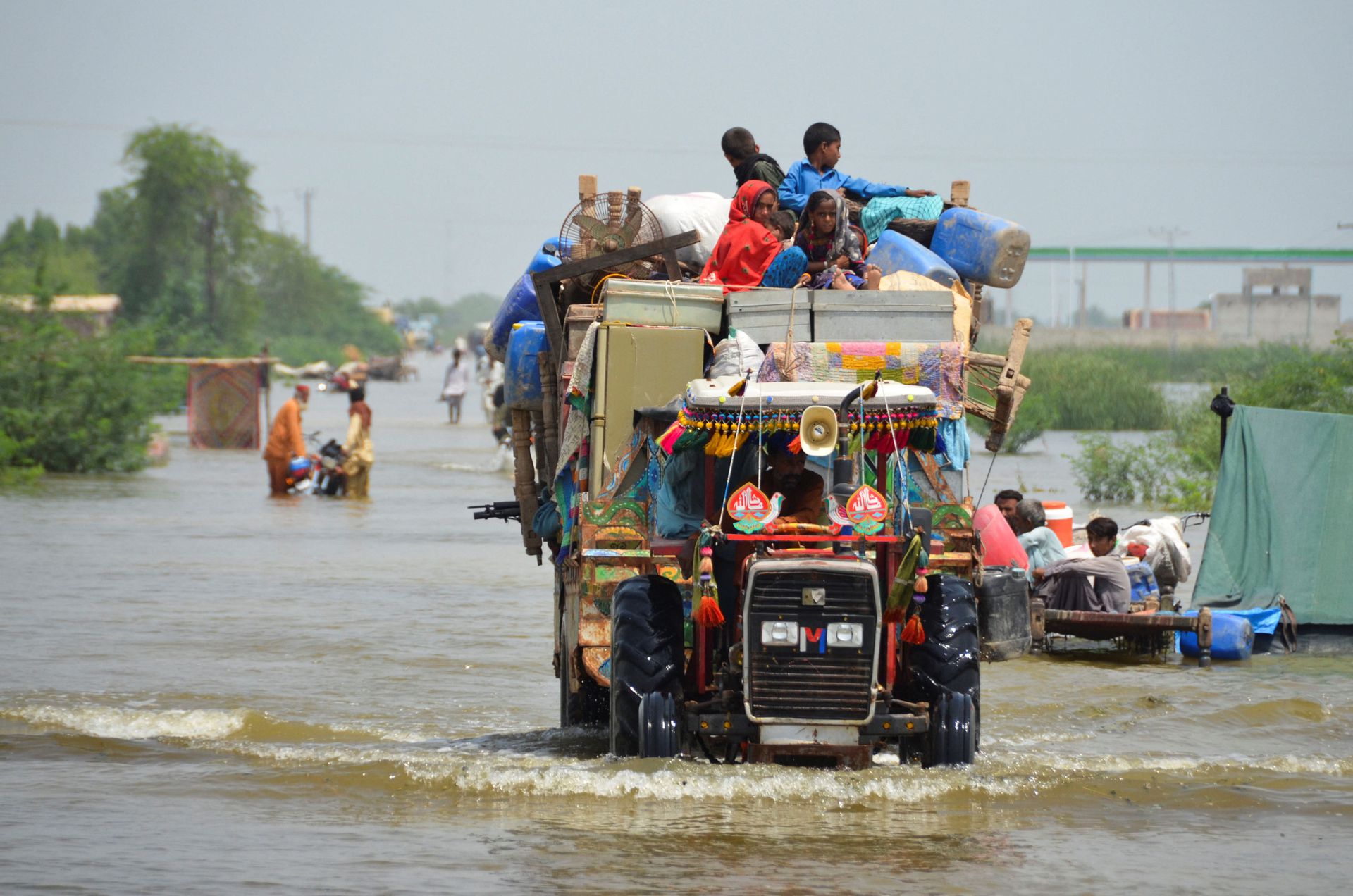 A family puts their belongings on a higher ground as they travel, following rains and floods during the monsoon season in Sohbatpur, Pakistan August 29, 2022. REUTERS/Amer Hussain