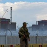 A serviceman with a Russian flag on his uniform stands guard near the Zaporizhzhia Nuclear Power Plant in the course of Ukraine-Russia conflict outside the Russian-controlled city of Enerhodar in the Zaporizhzhia region, Ukraine August 4, 2022. REUTERS/Alexander Ermochenko/File Photo