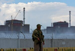 A serviceman with a Russian flag on his uniform stands guard near the Zaporizhzhia Nuclear Power Plant in the course of Ukraine-Russia conflict outside the Russian-controlled city of Enerhodar in the Zaporizhzhia region, Ukraine August 4, 2022. REUTERS/Alexander Ermochenko/File Photo