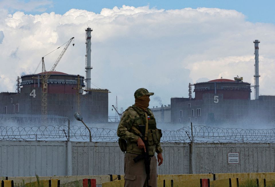 A serviceman with a Russian flag on his uniform stands guard near the Zaporizhzhia Nuclear Power Plant in the course of Ukraine-Russia conflict outside the Russian-controlled city of Enerhodar in the Zaporizhzhia region, Ukraine August 4, 2022. REUTERS/Alexander Ermochenko/File Photo