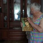 Taisia Herasymenko, 81, holds a picture of her son, Roman Herasymenko, who was shot and killed during the Russian occupation of Borodianka, Ukraine, July 5, 2022. REUTERS/Natalie Thomas
