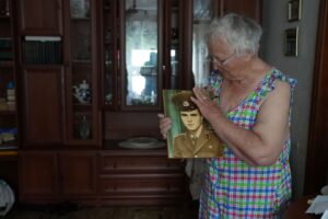Taisia Herasymenko, 81, holds a picture of her son, Roman Herasymenko, who was shot and killed during the Russian occupation of Borodianka, Ukraine, July 5, 2022. REUTERS/Natalie Thomas