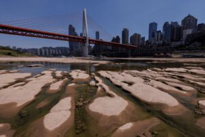 Qiansimen bridge runs over the dried-up riverbed of the Jialing river, a tributary of the Yangtze, that is approaching record-low water levels in Chongqing, China, August 18, 2022. REUTERS/Thomas Peter
