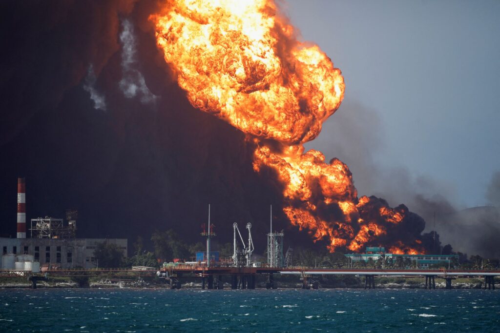 Fire is seen over fuel storage tanks that exploded near Cuba’s supertanker port in Matanzas, Cuba, August 8, 2022. REUTERS/Alexandre Meneghini