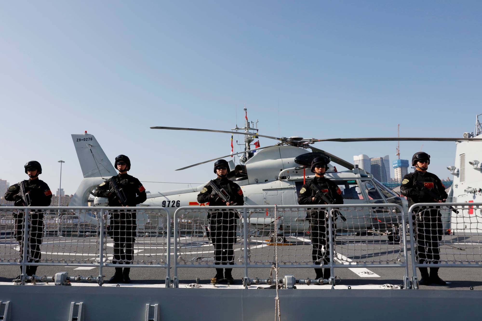 Chinese PLA Navy soldiers stand guard on the guided missile destroyer Xining as they depart for the escort mission in the Gulf of Aden and off the Somali coast, at a port in Qingdao