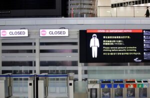 A notice about COVID-19 safety measures is pictured next to closed doors at a departure hall of Narita international airport on the first day of closed borders to prevent the spread of the new coronavirus Omicron variant in Narita, east of Tokyo, Japan, November 30, 2021. REUTERS/Kim Kyung-Hoon