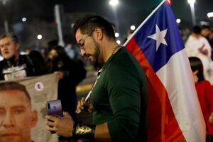 An opponent of the new Constitution listens to the partial results of a plebiscite on whether the new Constitution will replace the current Magna Carta imposed by a military dictatorship 41 years ago, in Santiago, Chile, Sunday, Sept. 4, 2022. (AP Photo/Cristobal Escobar)