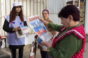 A volunteer of Luhansk regional election commission distributes newspapers to local citizens prior to a referendum in Luhansk, Luhansk People’s Republic controlled by Russia-backed separatists, eastern Ukraine, Thursday, Sept. 22, 2022. Authorities in Russian-controlled regions in eastern and southern Ukraine are preparing to hold referendums on becoming part of Russia — a move that could allow Moscow to escalate the war. The votes start Friday in the Luhansk, Kherson and partly Russian-controlled Zaporizhzhia and Donetsk regions. Writing on newspaper reads in Russian “27.09 Yes.” (AP Photo)