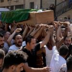 Mourners chant slogans as they carry the coffin of Palestinian Abdul-Al Omar Abdul-Al, 24, who was on a boat carrying migrants from Lebanon that sank in Syrian waters, during his funeral processions, in the Palestinian refugee camp of Nahr el-Bared near the northern city of Tripoli, Lebanon, Saturday, Sept. 24, 2022. Thousands of Palestinians held prayers in northern Lebanon Saturday for one of the scores of migrants who lost their lives this week when their boat sank off Syria’s coast. (AP Photo/Bilal Hussein)