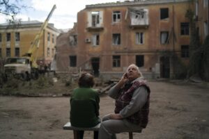 FILE – Raisa Smielkova, 75, looks up as she sits in front of the site were firefighters work to extinguish a fire as they look for potential victims after a Russian attack that heavily damaged a residential building in Sloviansk, Ukraine, on Sept. 7, 2022. Smielkova was sleeping at the time of the explosion. “You would be a fool not to be scared by this,” she says. “If someone asks, I say yes, I am scared.” (AP Photo/Leo Correa, File)