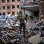 Student Karina Muzyka walks on the rubble of the Chernihiv School #21, which was bombed by Russian forces on the 3rd of March, in Chernihiv, Ukraine, Monday, Aug. 29, 2022. (AP Photo/Emilio Morenatti)