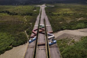 FILE – Containers block the Tienditas International Bridge, seen from Cucuta, Colombia, below, which connects with Tienditas, Venezuela, top, as the border has been partially closed for years by the Venezuelan government, Aug. 5, 2022. The presidents of Colombia and Venezuela announced on Sept. 9 that the years-long closure of their countries’ shared border to cargo transport will end Sept. 26. (AP Photo/Matias Delacroix, File)