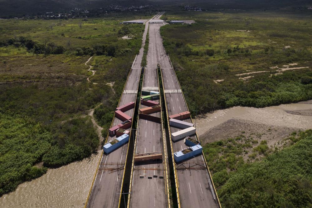 FILE – Containers block the Tienditas International Bridge, seen from Cucuta, Colombia, below, which connects with Tienditas, Venezuela, top, as the border has been partially closed for years by the Venezuelan government, Aug. 5, 2022. The presidents of Colombia and Venezuela announced on Sept. 9 that the years-long closure of their countries’ shared border to cargo transport will end Sept. 26. (AP Photo/Matias Delacroix, File)