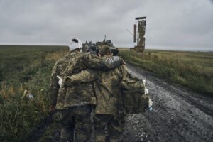 A Ukrainian soldier helps a wounded fellow soldier on the road in the freed territory in the Kharkiv region, Ukraine, Monday, Sept. 12, 2022. Ukrainian troops retook a wide swath of territory from Russia on Monday, pushing all the way back to the northeastern border in some places, and claimed to have captured many Russian soldiers as part of a lightning advance that forced Moscow to make a hasty retreat. (AP Photo/Kostiantyn Liberov)
