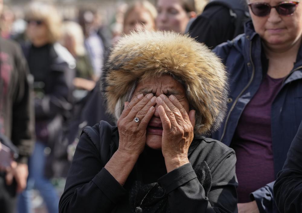 A mourner weeps as she pays respect to the Queen outside Buckingham Palace in London, Friday, Sept. 9, 2022. Queen Elizabeth II, Britain’s longest-reigning monarch and a rock of stability across much of a turbulent century, died Thursday Sept. 8, 2022, after 70 years on the throne. She was 96. (AP Photo/Kirsty Wigglesworth)