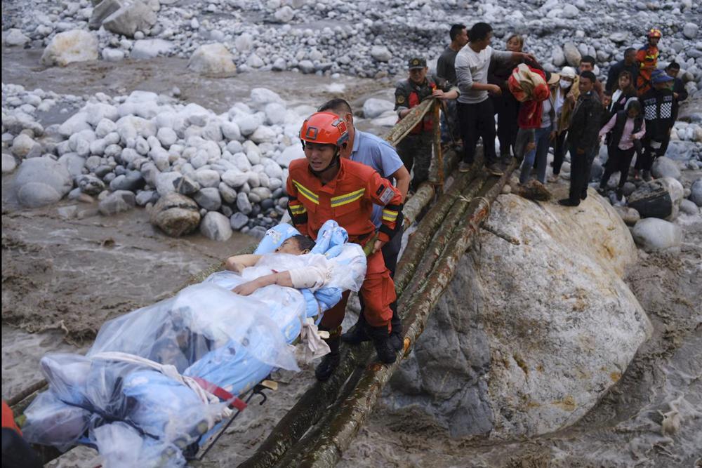In this photo released by Xinhua News Agency, rescuers transfer survivors across a river following an earthquake in Moxi Town of Luding County, southwest China’s Sichuan Province on Monday, Sept. 5, 2022. Dozens people were reported killed and missing in a 6.8 magnitude earthquake that shook China’s southwestern province of Sichuan on Monday, triggering landslides and shaking buildings in the provincial capital of Chengdu, whose 21 million residents are already under a COVID-19 lockdown. (Cheng Xueli/Xinhua via AP)