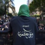 A Hezbollah member wears a vest with Arabic that reads: “40 years and we stay with Hussein (the Prophet Muhammad’s grand son),” during the holy day of Ashoura that commemorates the 7th century martyrdom of the Prophet Muhammad’s grandson Hussein, in the southern suburb of Beirut, Lebanon, Aug. 9, 2022. Forty years since it was founded, Lebanon’s Hezbollah has transformed from a ragtag organization to the largest and most heavily armed militant group in the Middle East. (AP Photo/Hussein Malla)