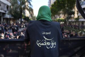A Hezbollah member wears a vest with Arabic that reads: “40 years and we stay with Hussein (the Prophet Muhammad’s grand son),” during the holy day of Ashoura that commemorates the 7th century martyrdom of the Prophet Muhammad’s grandson Hussein, in the southern suburb of Beirut, Lebanon, Aug. 9, 2022. Forty years since it was founded, Lebanon’s Hezbollah has transformed from a ragtag organization to the largest and most heavily armed militant group in the Middle East. (AP Photo/Hussein Malla)