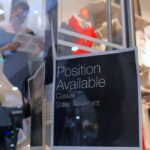 A sales assistant is seen through the window of a retail store displaying a job vacancy sign in central Sydney, Australia, December 5, 2016. Picture taken December 5, 2016. REUTERS/Steven Saphore
