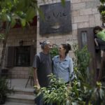 FILE – Kenae Totah, 5, right, plays while his parents Morgan Cooper, 41, center and foreign spouse Saleh Totah, right, pose for a photo in front of their restaurant, at the West Bank city of Ramallah, Monday, May 2, 2022. Israel published a new set of rules and restrictions Sunday, Sept. 4, 2022, for foreigners who want to enter or live in Palestinian areas of the West Bank, including a requirement that people who form romantic relationships with local Palestinians register with Israeli authorities. (AP Photo/Nasser Nasser, File)