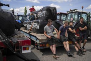 FILE- Protesting farmers talk at a blockade outside a distribution center for supermarket chain Aldi in the town of Drachten, northern Netherlands, on July 4, 2022. The Dutch agriculture minister has unexpectedly resigned following a tumultuous summer of protests by farmers over pollution regulations. Minister of Agriculture Henk Staghouwer told reporters he was not suitable for the job. (AP Photo/Peter Dejong, File)