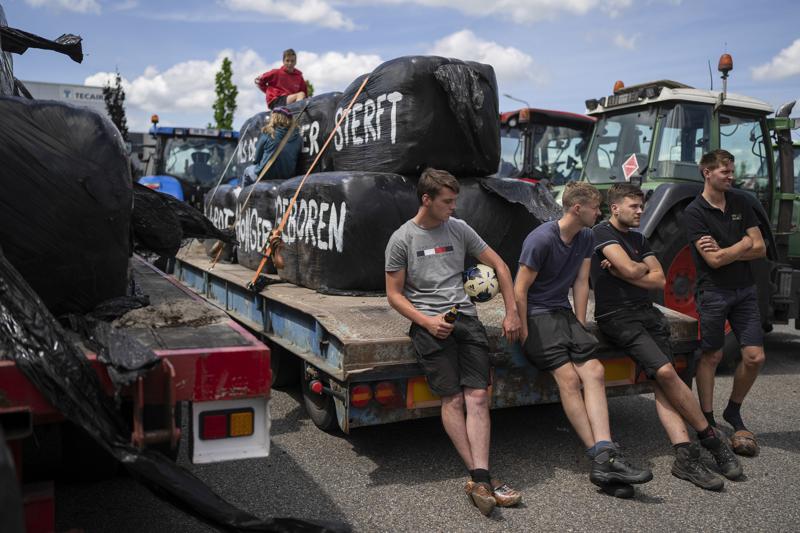 FILE- Protesting farmers talk at a blockade outside a distribution center for supermarket chain Aldi in the town of Drachten, northern Netherlands, on July 4, 2022. The Dutch agriculture minister has unexpectedly resigned following a tumultuous summer of protests by farmers over pollution regulations. Minister of Agriculture Henk Staghouwer told reporters he was not suitable for the job. (AP Photo/Peter Dejong, File)