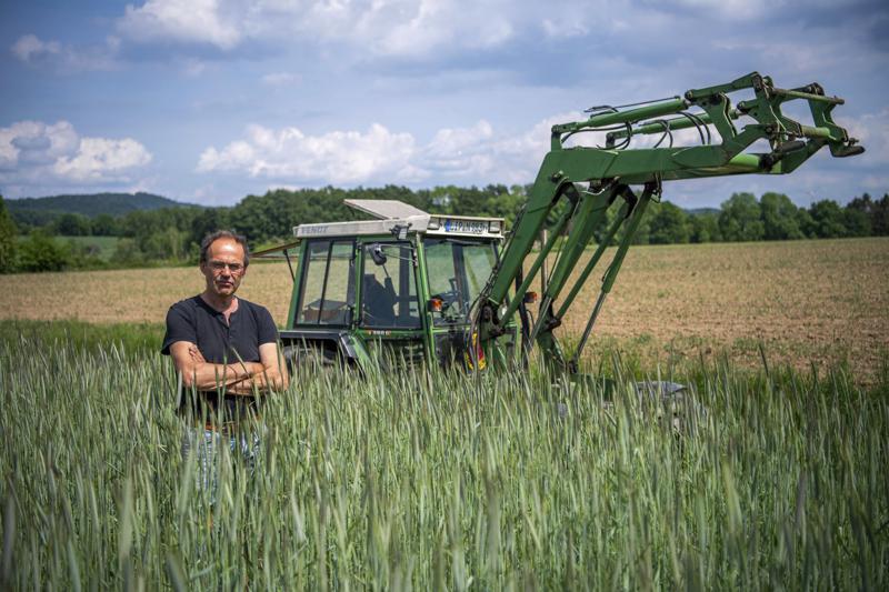 FILE – Ulf Allhoff-Cramer, farmer, stands in a rye field in front of his tractor in Detmold, Germany, on May 18, 2022. Environmentalists claimed a small legal victory Friday, Sept. 9, 2022, after a court in Germany said it would continue hearing a case brought by a local farmer seeking to force automaker Volkswagen to the sale of combustion engine vehicles. The plaintiff, Ulf Allhoff-Cramer, says drier soil and heavier rains due to climate change are harming his fields, cattle and commercial forests. (Lino Mirgeler/dpa via AP)