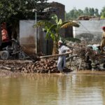 A man clears rubble of his makeshift stall amid flood water, following rains and floods during the monsoon season in Nowshera, Pakistan September 2, 2022. REUTERS/Fayaz Aziz