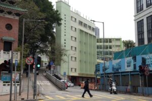 A pedestrian wearing a face mask following the coronavirus disease (COVID-19) outbreak, walks past a primary school in Hong Kong, China February 23, 2022. REUTERS/Lam Yik