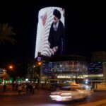 A building is illuminated with a picture of Pope Francis with Iraq’s top Shi’ite cleric, Grand Ayatollah Ali al-Sistani, in Baghdad, Iraq March 7, 2021. REUTERS/Khalid al-Mousily/File Photo